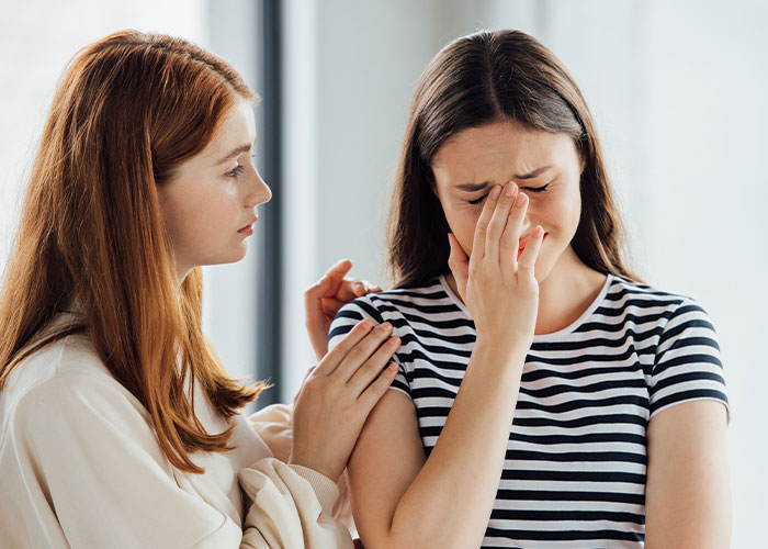 Friend consoles crying woman, affected by accidental pre-wedding mix-up. Friend consoles crying woman, affected by accidental pre-wedding mix-up.