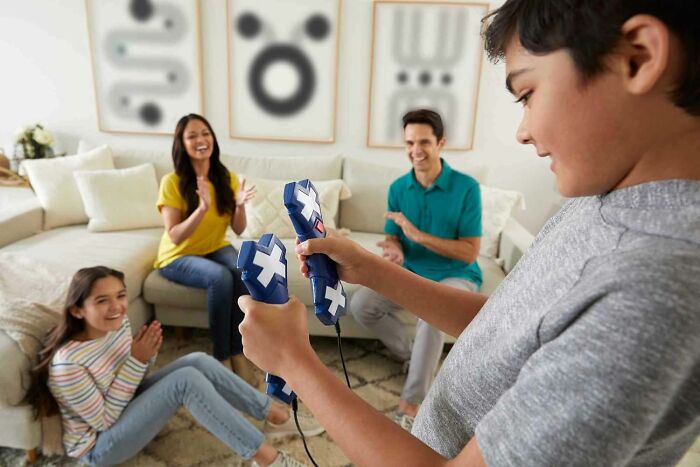 Family playing video games together indoors, keeping kids entertained during cold weather cabin fever times.