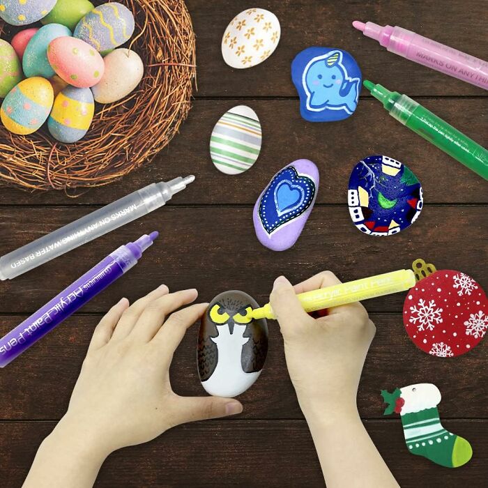 Child painting decorative stones with colorful markers as a fun way to keep kids entertained when it's too cold outside
