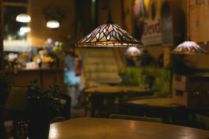 Cozy dimly lit cafe interior featuring stained glass pendant lamps and blurred background, evoking mind-blowing coincidences.
