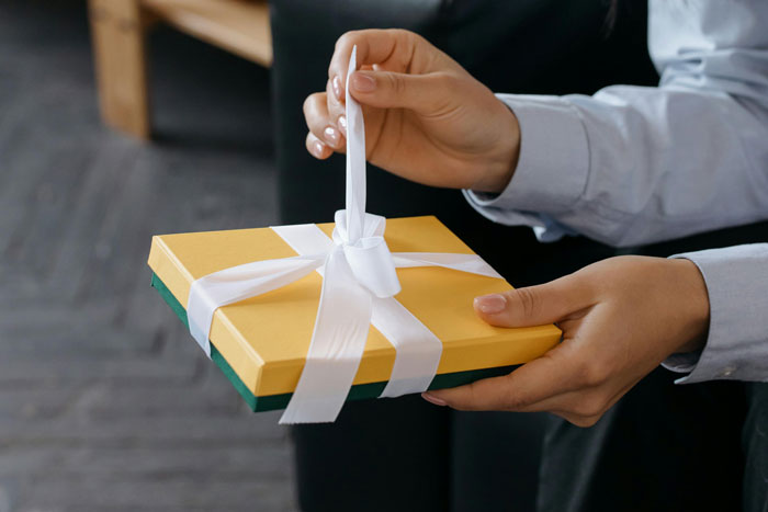 Hands holding a wrapped gift, symbolizing entitled behavior and relationship challenges over wedding gifts. Hands holding a wrapped gift, symbolizing entitled behavior and relationship challenges over wedding gifts.