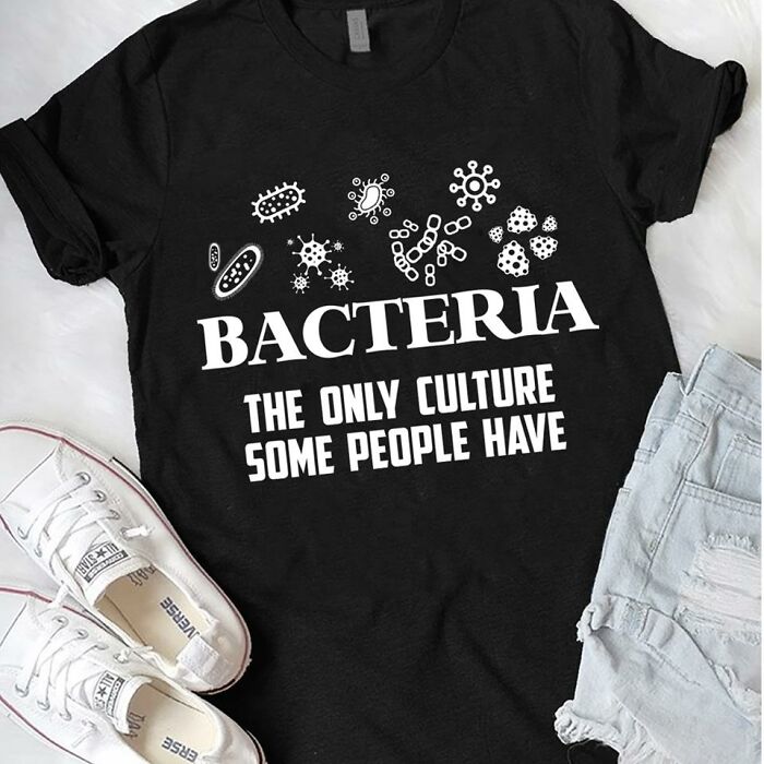 Black t-shirt with white bacteria illustrations and humorous science text about culture, paired with white sneakers and denim shorts.