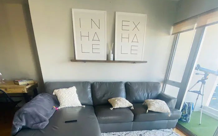 Cringeworthy design fail with mismatched "inhale" and "exhale" wall art above a gray sofa.