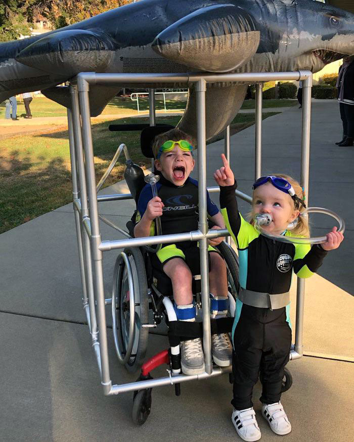 Two kids in creative Halloween costume ideas, one in a wheelchair with scuba gear and the other dressed as a diver.