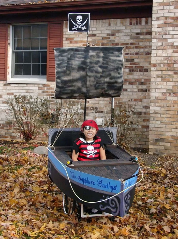 Child in a creative pirate ship costume surrounded by autumn leaves, showcasing kids Halloween costume ideas that worked like magic.