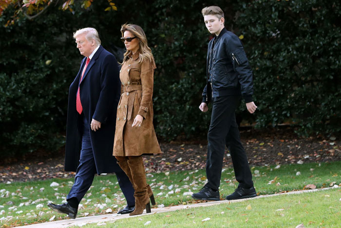 Barron Trump walking alongside Donald and Melania Trump, his height noticeably taller than both, dressed in all black, capturing attention. Barron Trump walking alongside Donald and Melania Trump, his height noticeably taller than both, dressed in all black, capturing attention.