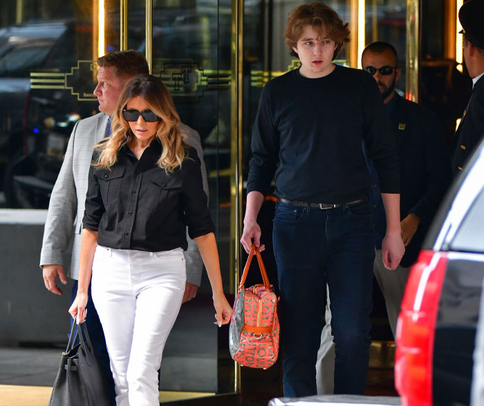 Barron Trump, noticeably taller, walks beside Melania Trump, wearing casual black and jeans, further highlighting Barron Trump's height. Barron Trump, noticeably taller, walks beside Melania Trump, wearing casual black and jeans, further highlighting Barron Trump's height.
