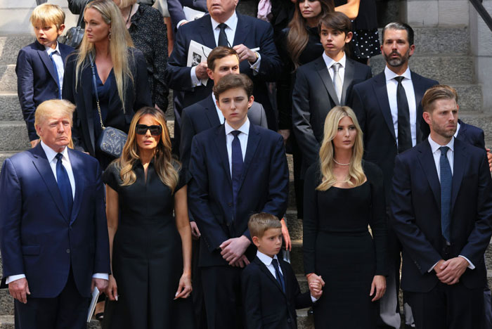 Barron Trump stands in the center of a formal family gathering, his height towering over others, accentuating Barron Trump's height in the group. Barron Trump stands in the center of a formal family gathering, his height towering over others, accentuating Barron Trump's height in the group.