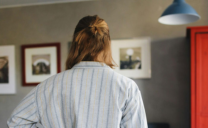Person with brown hair in a striped shirt standing indoors, illustrating moments that turn friends to strangers in seconds.