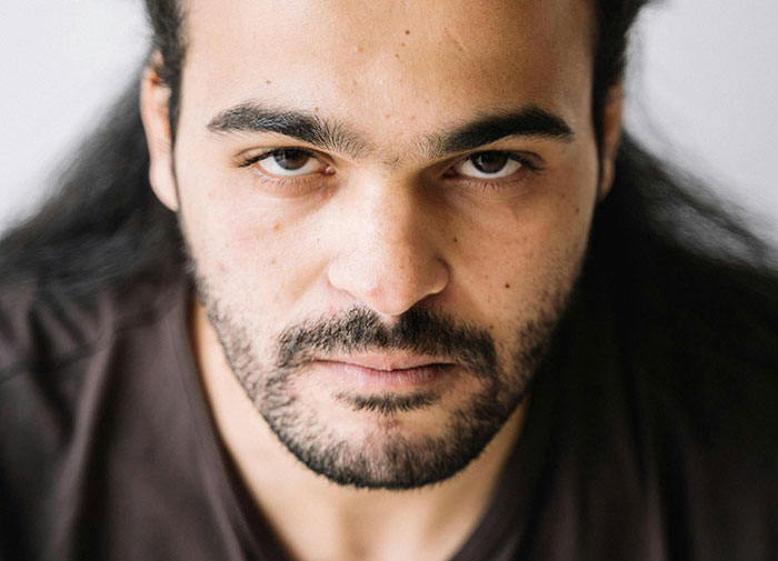 Close-up of a man with a serious expression reflecting feelings of shame in moments that turn friends to strangers.