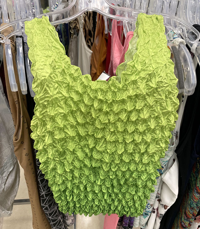 Lime green textured top hanging on a rack representing fast disappearing internet trends in fashion.