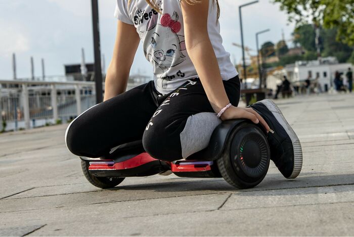 Person wearing casual clothes sitting on a hoverboard, representing fast fading internet trends and viral sensations.