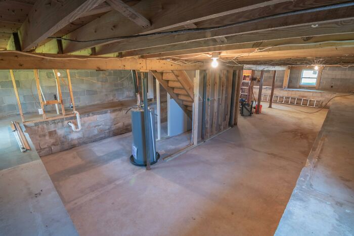 Empty basement with exposed beams and concrete floor illustrating a mind-blowing coincidence in home construction.