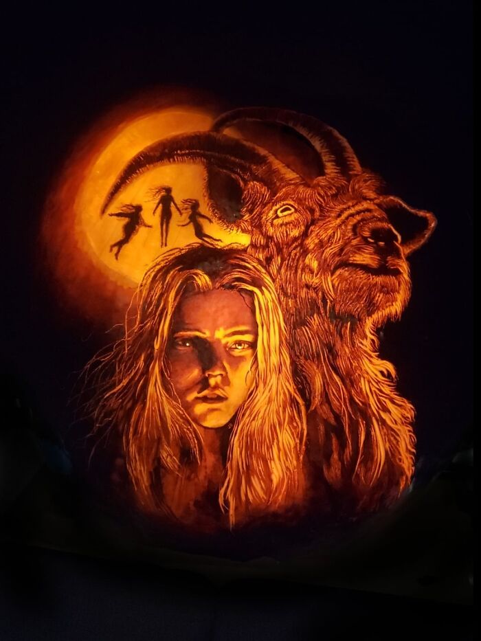 Intricately carved pumpkin featuring a detailed woman’s face, a goat, and silhouettes under a glowing moon for spooky pumpkin carvings.