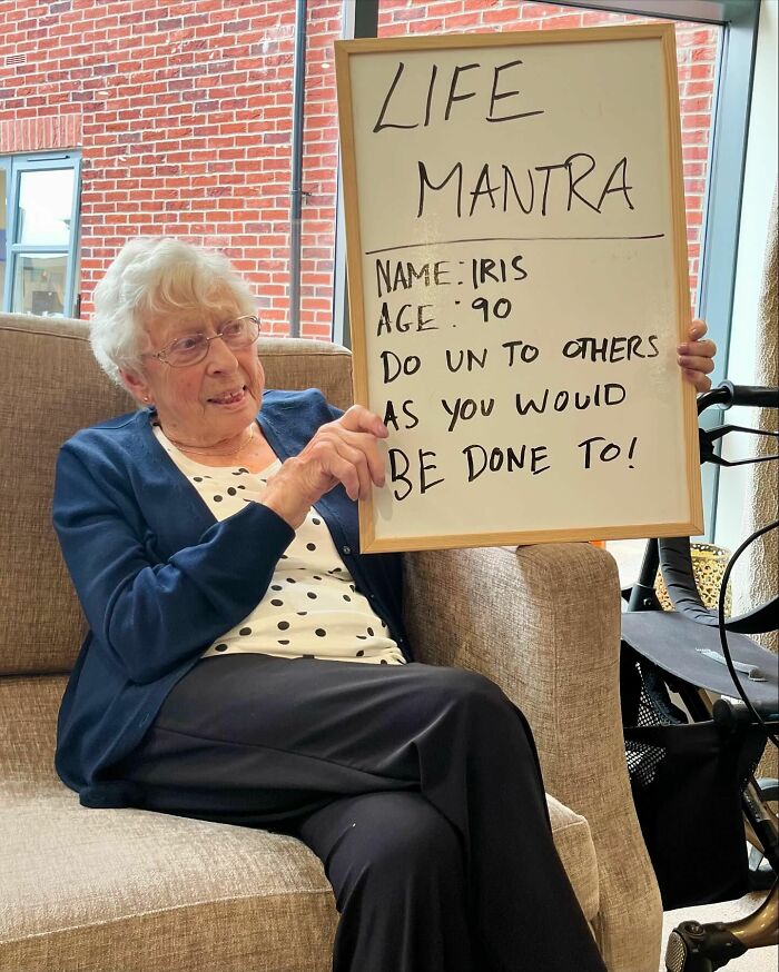 Elderly woman sharing life advice on a whiteboard in a cozy setting, highlighting elders doling out life advice.