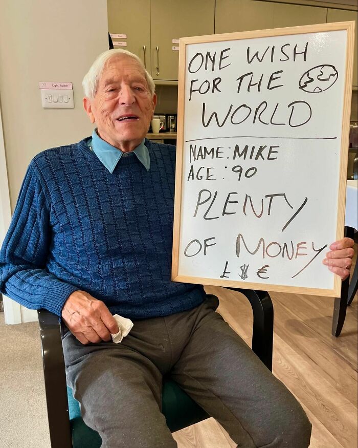 Elderly man named Mike holding sign with life advice about money on Instagram page dedicated to elders doling out wisdom.
