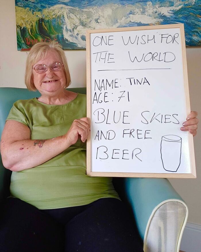 Elderly woman named Tina holding a board with a wish, featured on Instagram page dedicated to life advice from elders.