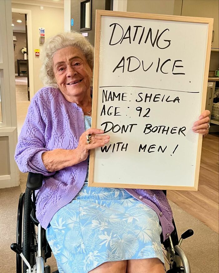Elderly woman in a wheelchair sharing dating advice on a whiteboard from an Instagram page dedicated to life advice.