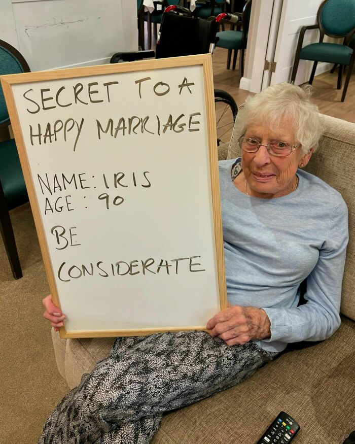Elderly woman holding whiteboard with life advice about marriage, featured on Instagram page dedicated to elders' hard truths.