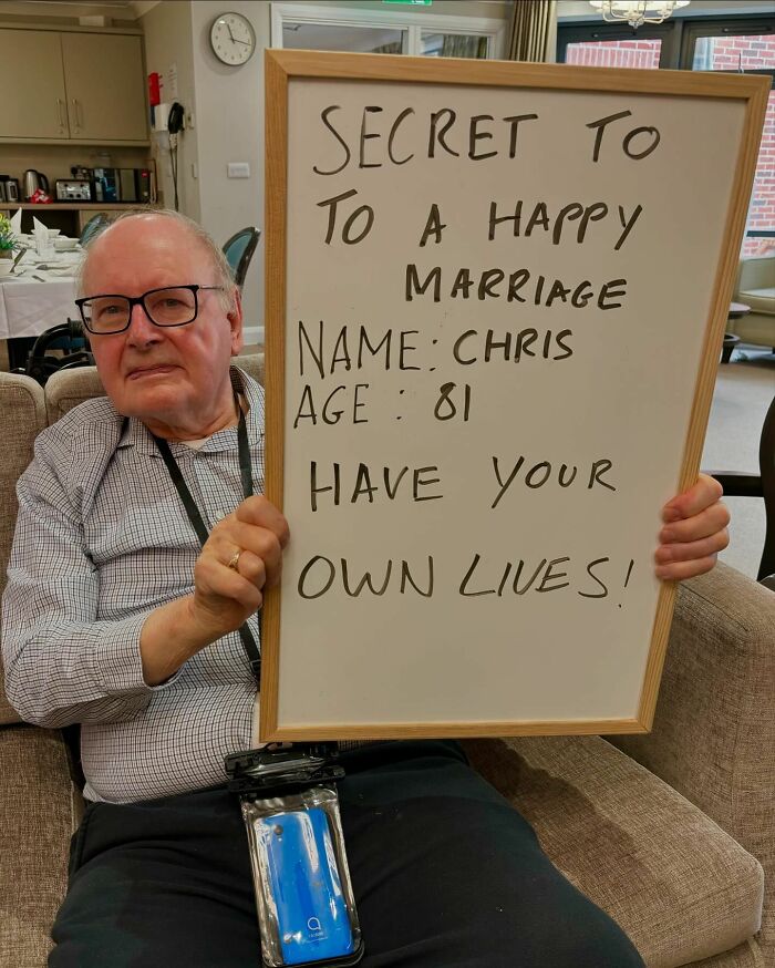 Elderly man holding advice board about happy marriage, part of Instagram page sharing elders life advice and hard truths.