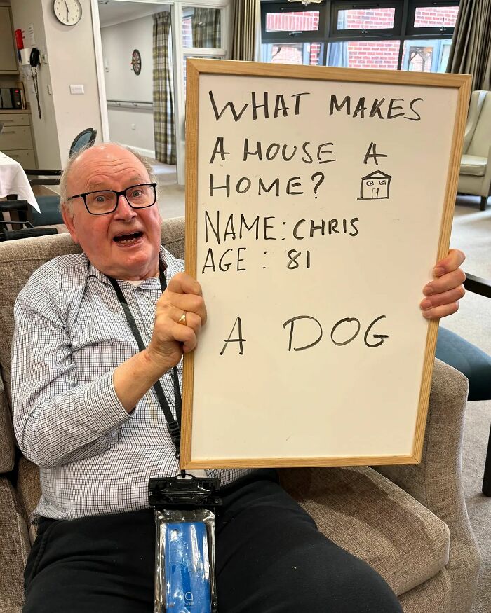 Elderly man holding a whiteboard sharing life advice about what makes a house a home for an Instagram page dedicated to elders.