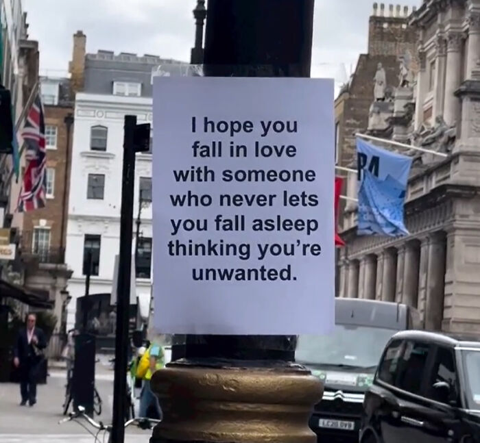 Wholesome message on London street lamp encouraging love and kindness to inspire people's hearts and minds.