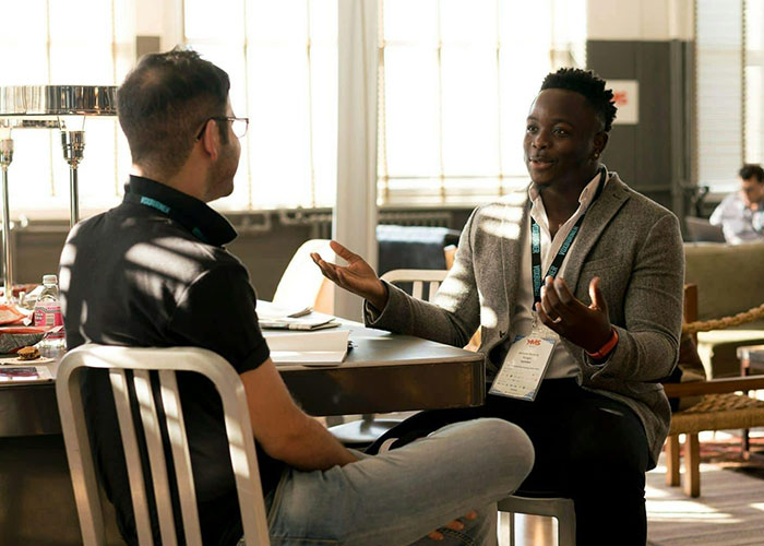 Two men having a thoughtful conversation, showing indicators the person is super smart and hides it well in a casual setting.