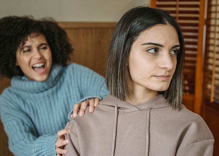 Two women in conversation, one appearing thoughtful and the other engaging, showing indicators of hidden intelligence.