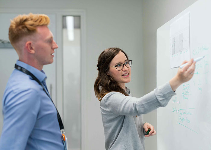 Two colleagues engaged in discussion, demonstrating indicators that the person you’re talking to is super smart and hides it well.