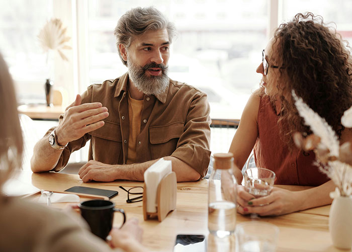 Two people having a thoughtful conversation, showing indicators of a super smart person who hides it well in a casual setting.