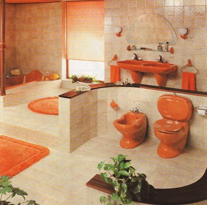 Vintage bathroom interior from the ’50s to ’80s featuring bold orange fixtures and retro design elements in tiled room.