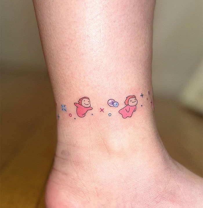 Small tattoo of cute pink creatures on an ankle, showcasing a playful and minimalist design.