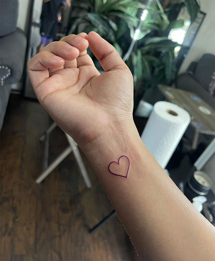 Minimalist small heart tattoo on wrist, showcasing unique small tattoo ideas.