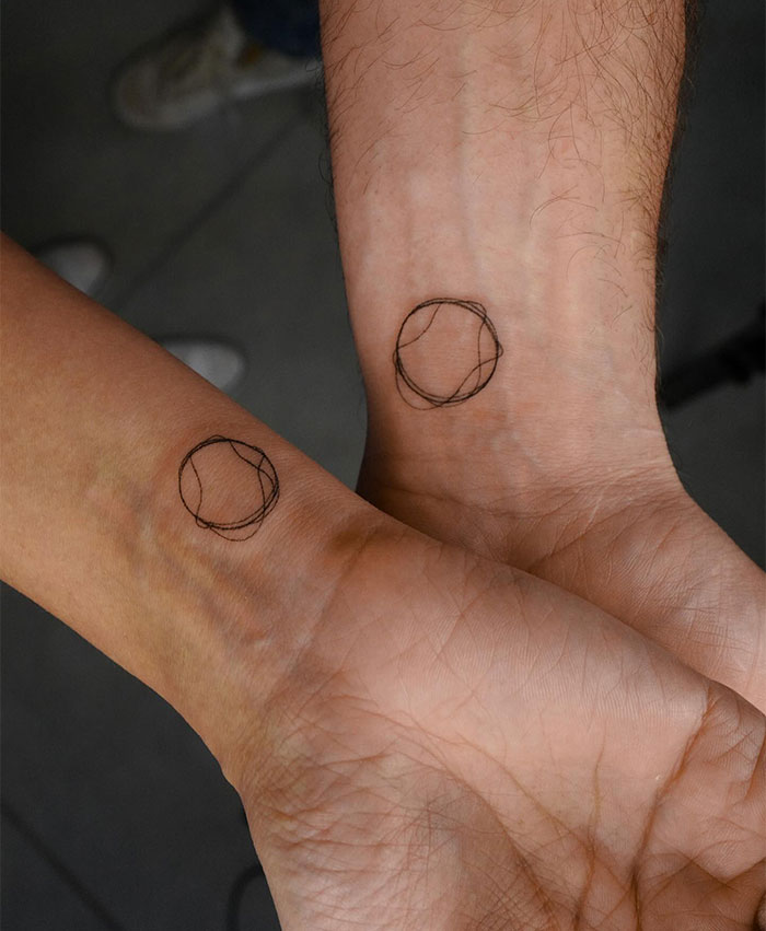 Small tattoos: minimalist circle designs on wrists, displaying simple yet impactful ink art.
