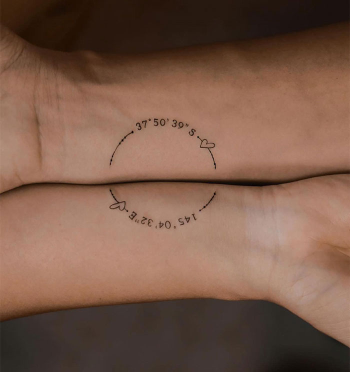Close-up of small tattoo featuring coordinates and hearts on a wrist, showcasing creative small tattoo ideas.