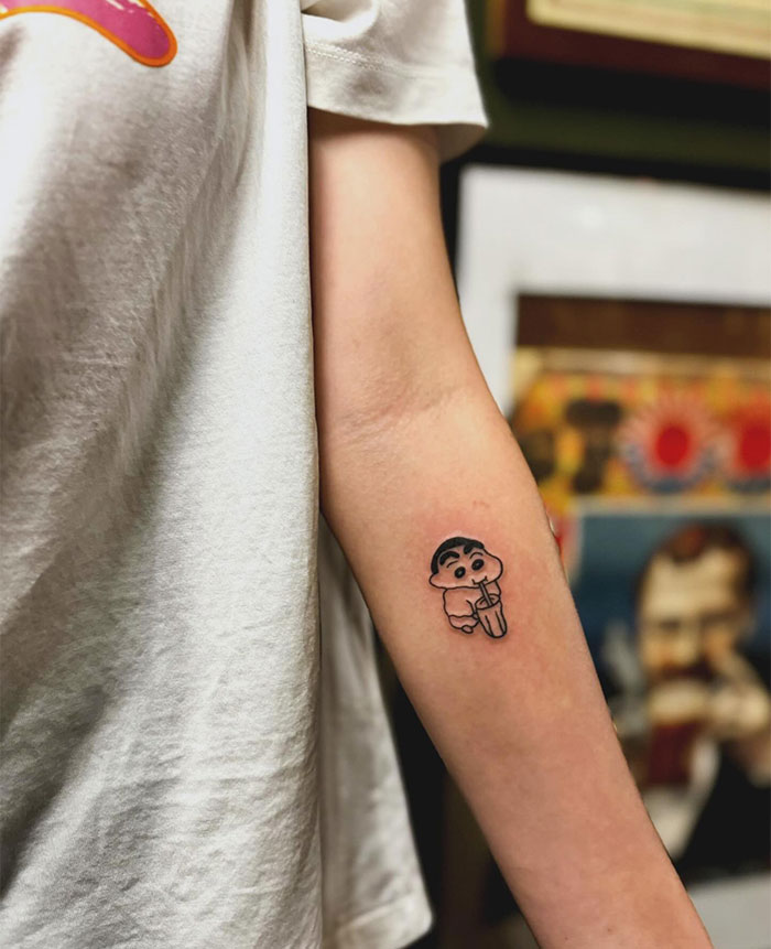 Small tattoo of a cartoon character on forearm, showcasing unique and creative tattoo ideas.
