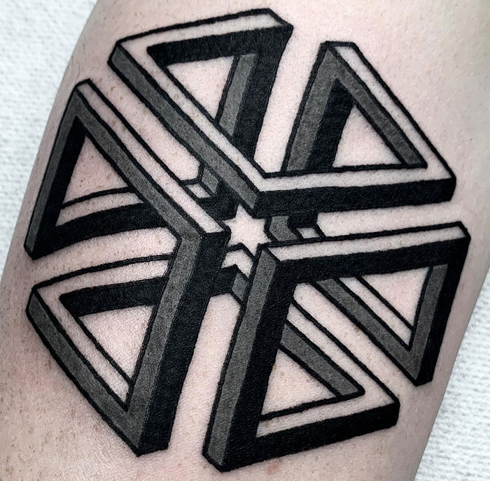Small tattoo idea featuring a geometric star design in bold black lines on the arm.