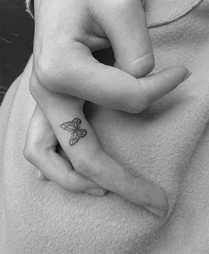 Close-up of a hand with a small butterfly tattoo, showcasing small tattoo ideas.