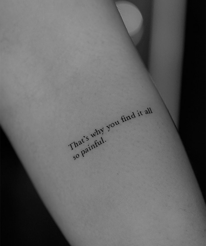 Small tattoo of a meaningful quote on arm, conveying deep emotion.