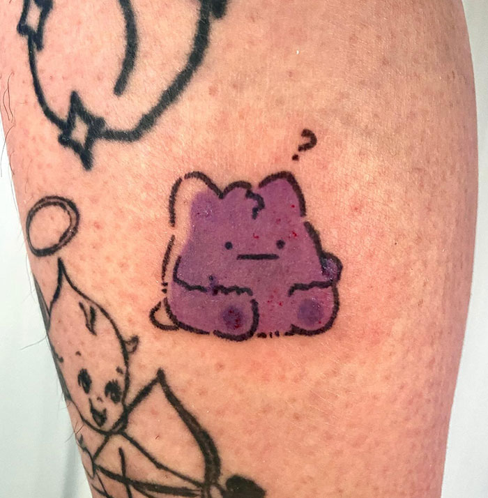 Purple cartoon character tattoo, small in size, on skin, part of small tattoo ideas collection.