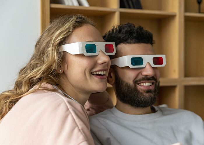 Couple wearing 3D glasses smiling and enjoying a trend that quickly disappeared after taking the internet by storm.