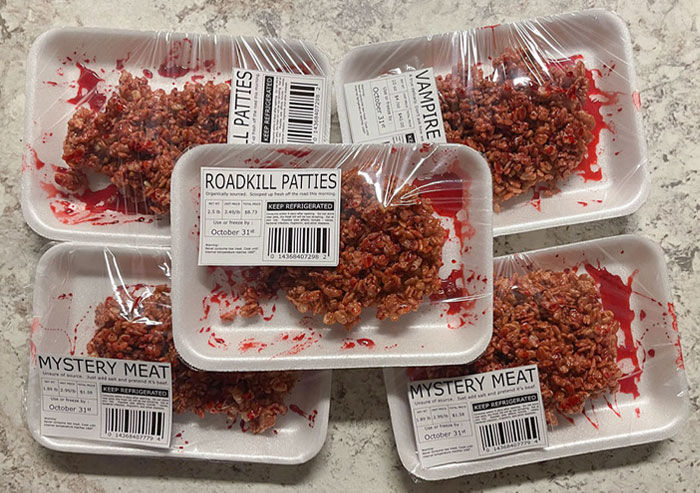Halloween snacks styled as realistic bloody meat patties in foam trays with fake blood and labels like Roadkill Patties and Mystery Meat.
