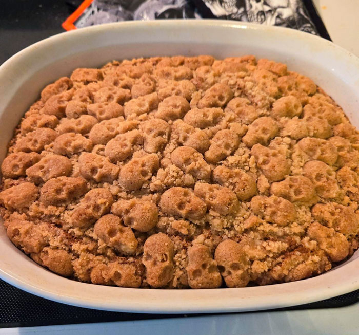 Halloween snack dessert baked in a dish with a topping of crunchy skull-shaped crumbs and crumble topping.