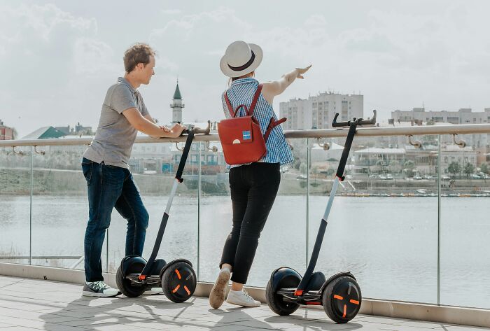 Two people on electric scooters near a waterfront, illustrating popular trends that disappeared quickly online.