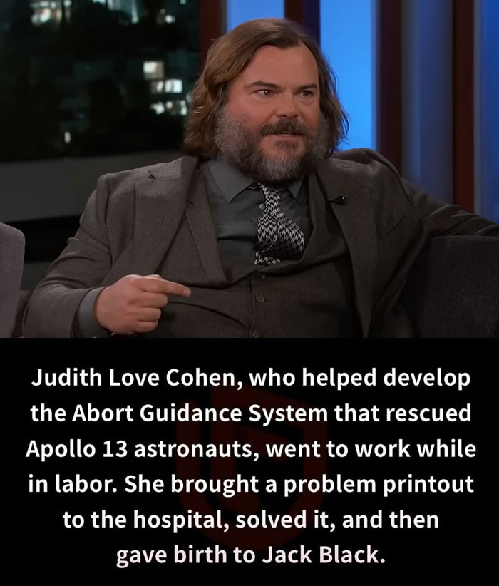 Man in a suit on a talk show set, discussing unbelievable facts with a serious expression.