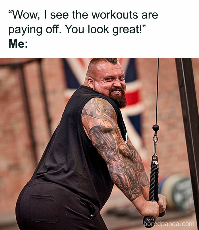 Man jokingly flexes muscles at gym, embodying funny gym meme about the agony of “just one more rep.”