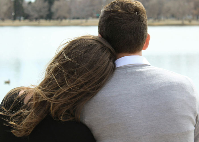 A couple sitting by a lake, highlighting struggles men wish women knew.