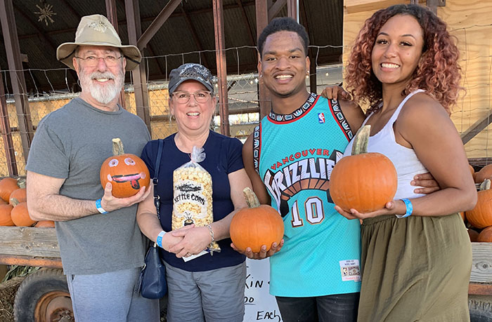 Group of friends celebrating with pumpkins, highlighting viral strangers-turned-friends enjoying their Thanksgiving together.