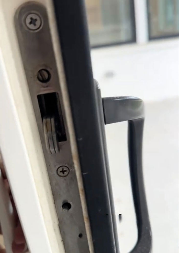 Close-up of a door lock in a two-year-old $1,600,000 home, showing poor condition.