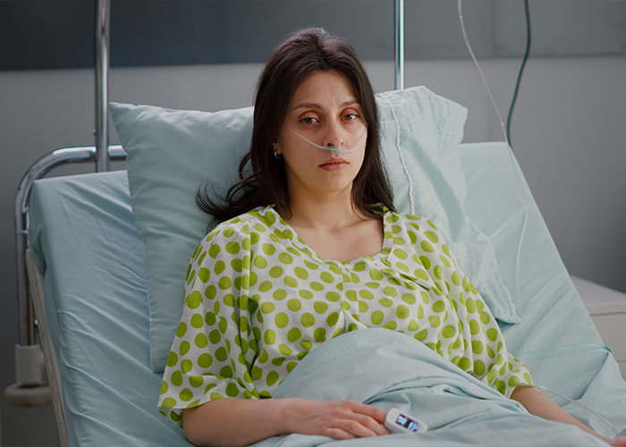 Woman in a hospital bed with a nasal cannula, illustrating reasons behind divorce for married couples.